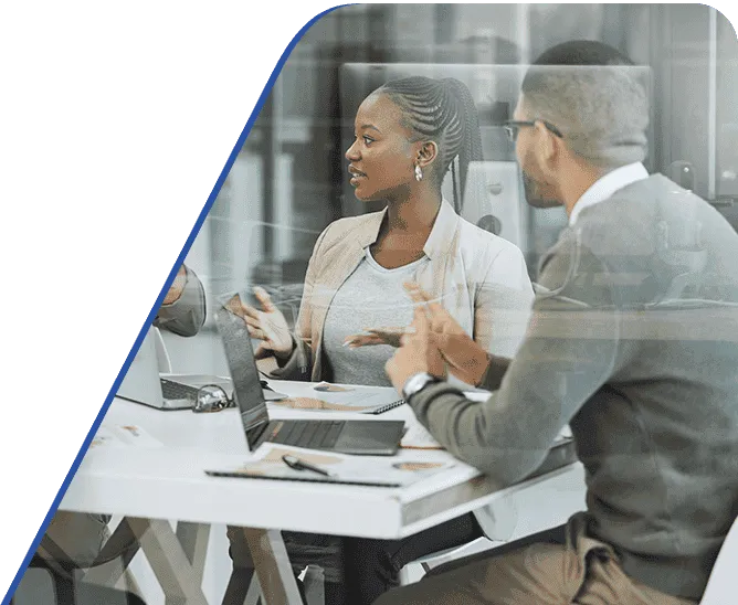 Amtivo (Formerly Certification Europe and EQA) - ISO 22301 Business Continuity Management - discussion between colleagues siting at a table with their laptops and notepads.