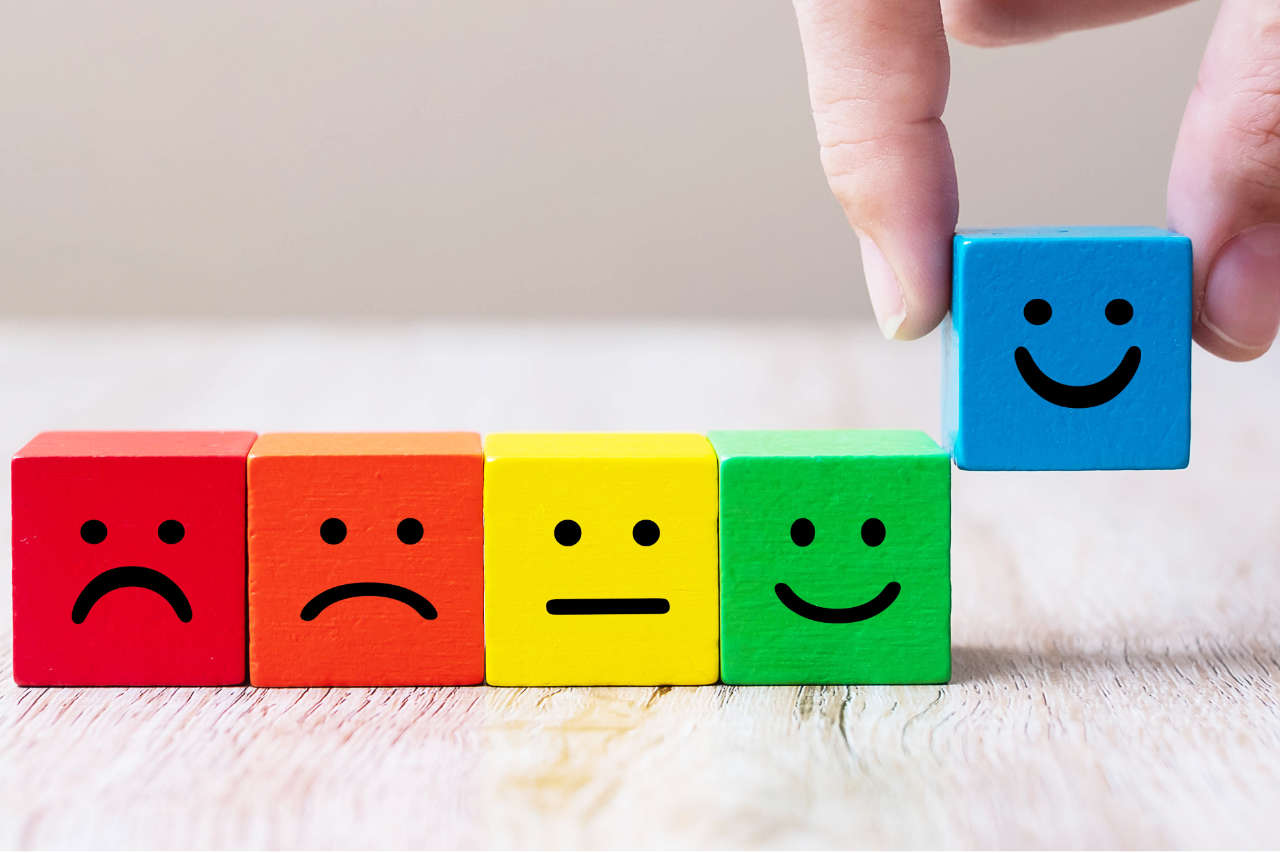 Emotion face symbol on yellow wooden cube blocks. Service rating