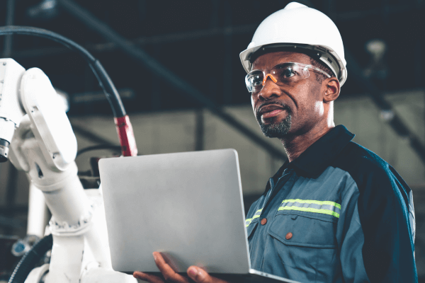 What is a Quality management system – man in white hard hat in factory with laptop
