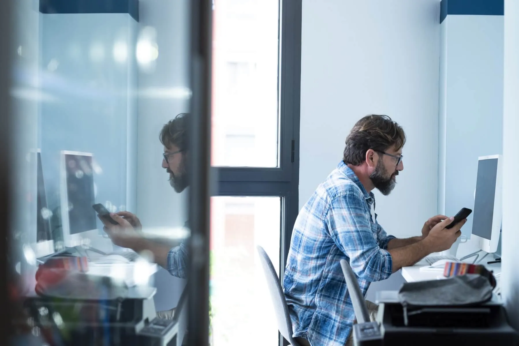 Adult business man work at office with mobile phone and desktop