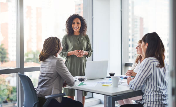 Business women, presentation and meeting with PR management and planning campaign project. Laptop, professional and diversity at agency with press release and brand growth in office with speaker