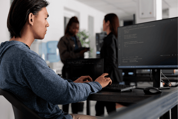 Software developer coding at a desk in a modern office